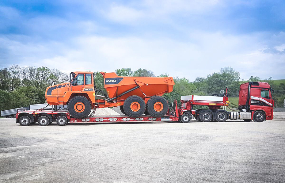 Heavy equipment transportation: Large dump truck on a lowboy trailer